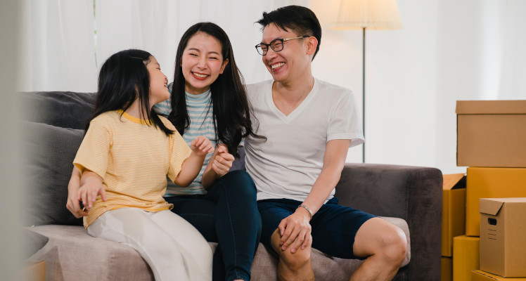 Happy Asian family sitting on the sofa